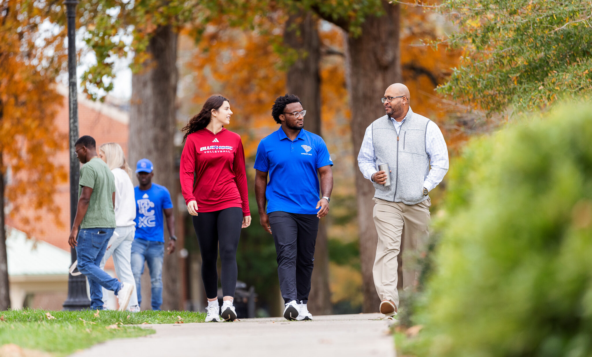 Presbyterian College students walking with a professor through campus.