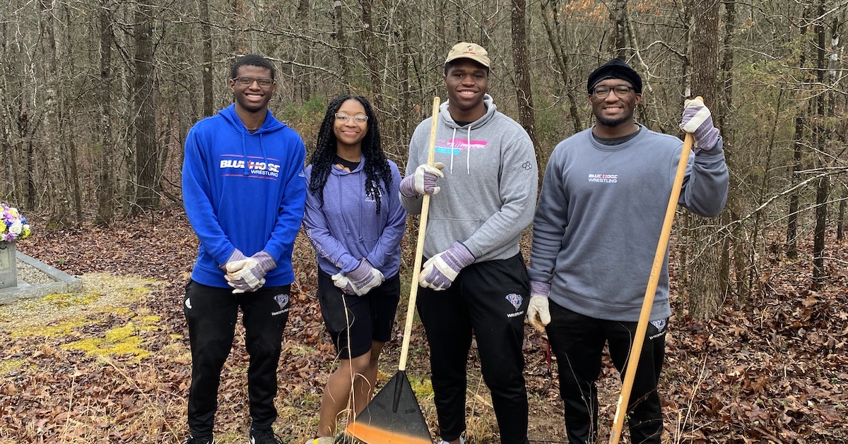 Presbyterian College student volunteers with cleaning equipment.