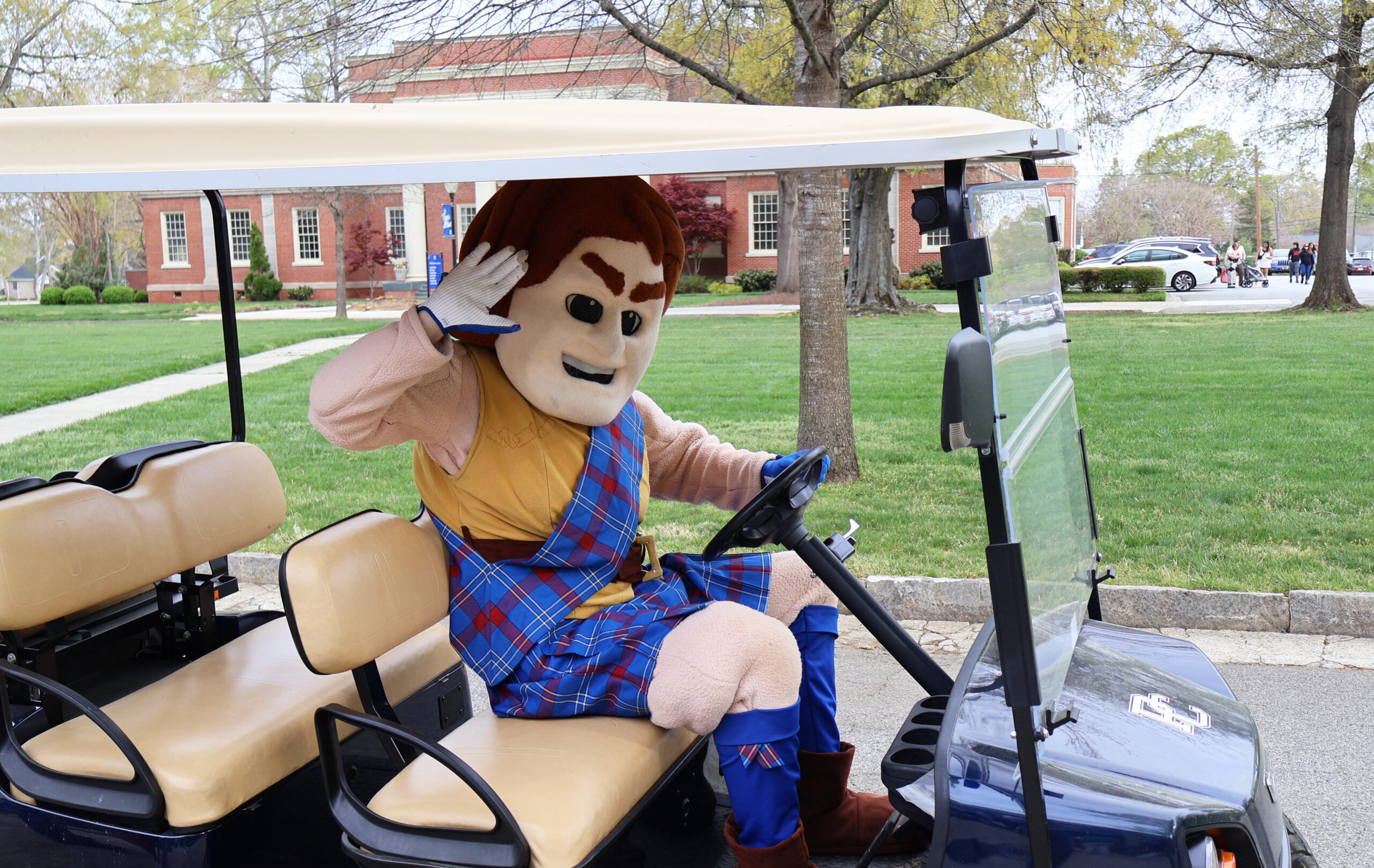 Scotty the Scotsman driving a golf cart.
