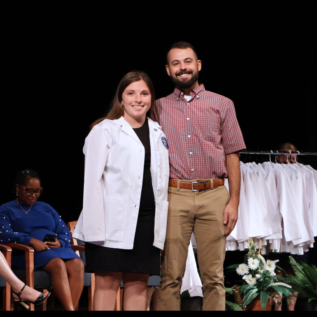 Anna Chiarelli Occupational Therapy Class of 2027 posing with her white coat. 