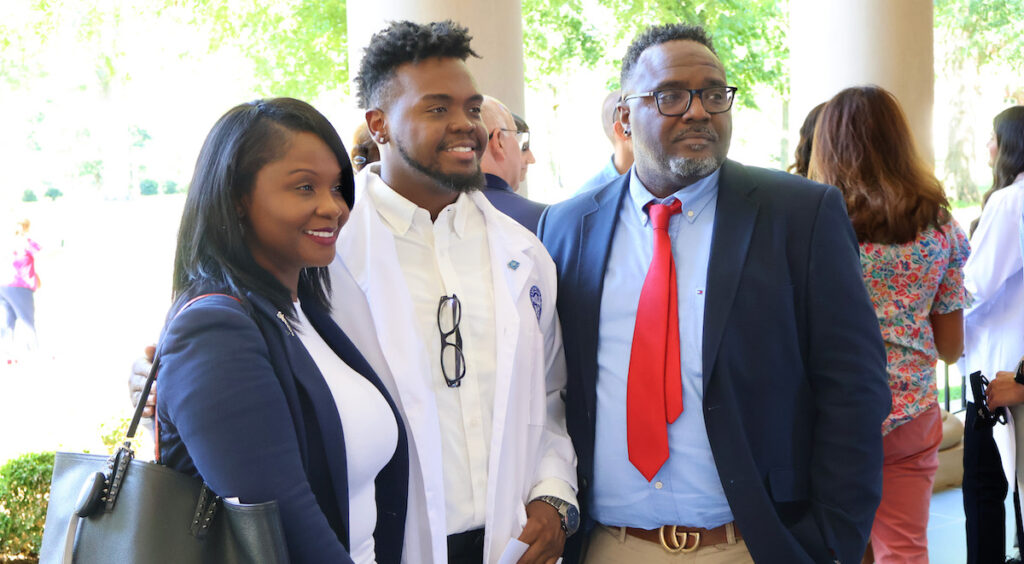 After receiving his white coat, a member of the latest cohort in the Presbyterian College Occupational Therapy Doctoral Program gathers with family in front of Belk Auditorium.