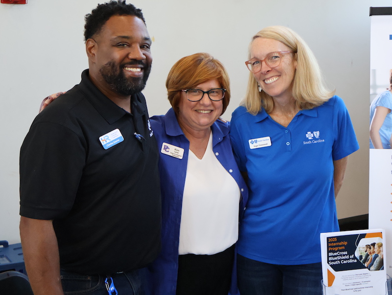 Kim Lane taking a picture with employers at a job fair. 