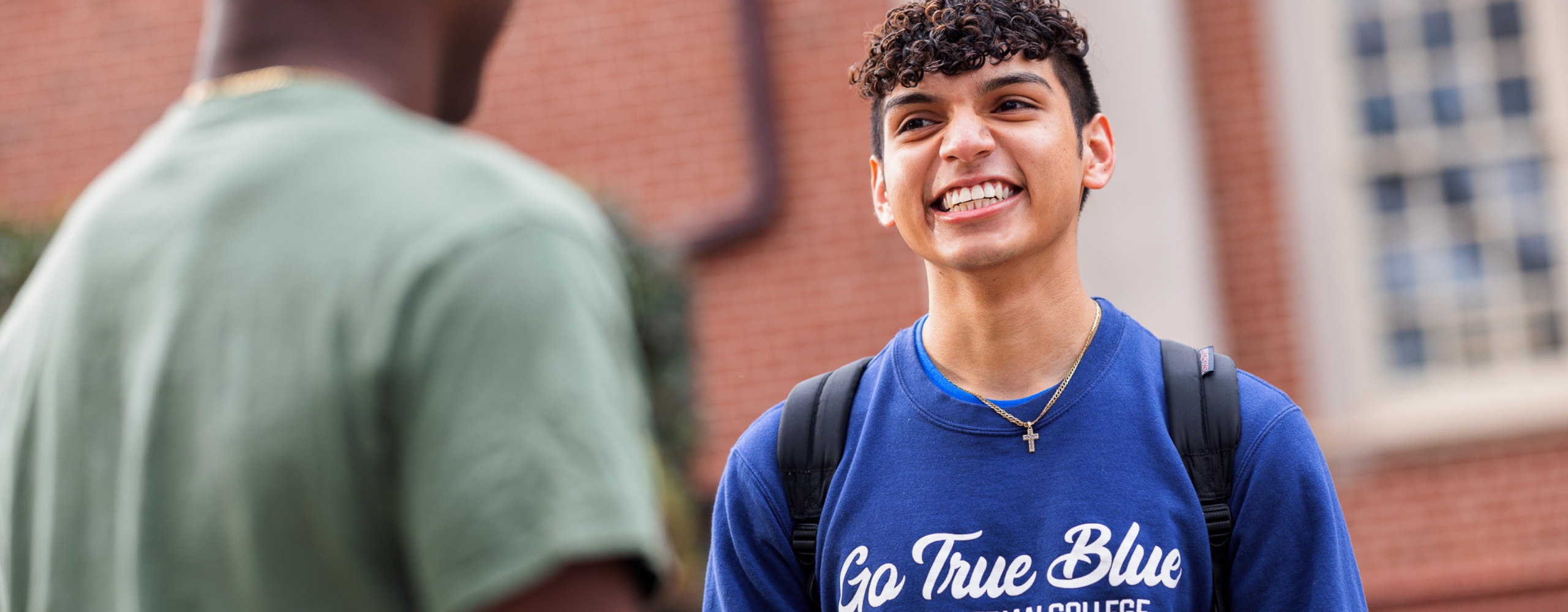 PC student smiling outside of the library.